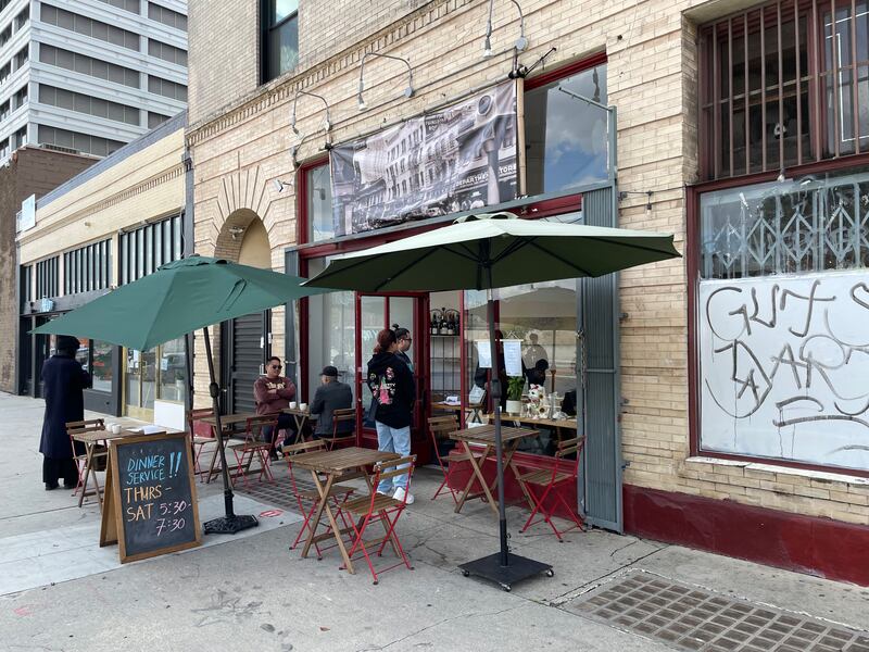 Photo of the outside of a restaurant with tables set up.