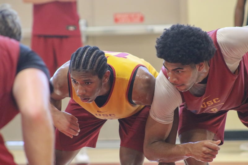 Jerry Easter II (8) and Jacob Cofie (6) elbow each other as they both box out at the free throw line. Easter II wears a gold practice jersey, while Cofie wears a cardinal practice jersey.