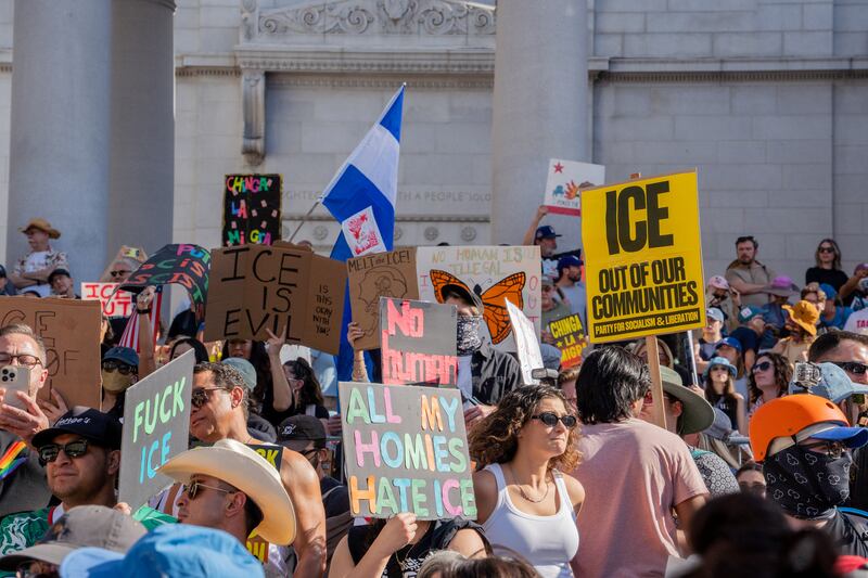 标语包含“ICE滚出我们的社区”,“我的朋友们都恨ICE”,“ICE很可恶”。