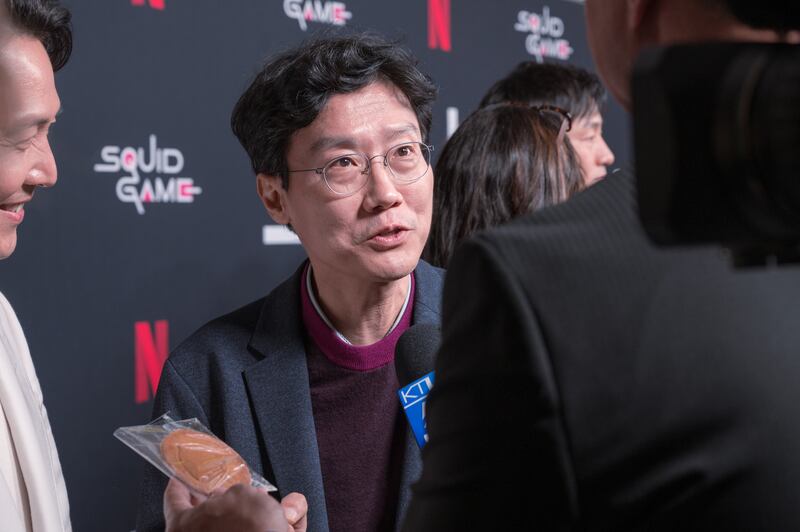 "Squid Game" director Hwang Dong-hyuk gives tips to KTLA 5 anchor Doug Kolk on how to succeed in the Dalgona Challenge at the "Squid Game" red carpet event hosted by Netflix at NeueHouse Hollywood on Nov 8 2021.