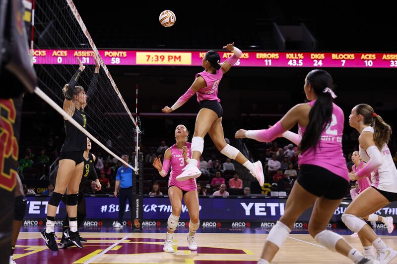 Mia Tvrdy (8) rises up above the net intent on spiking an approaching volleyball. She is surrounded by USC teammates.