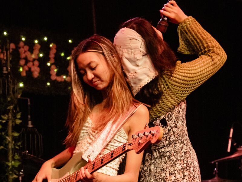 Photo of a singer singing back to back with a guitarist