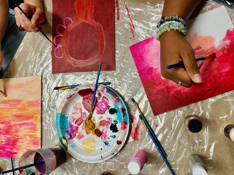A group of people paint for art therapy.