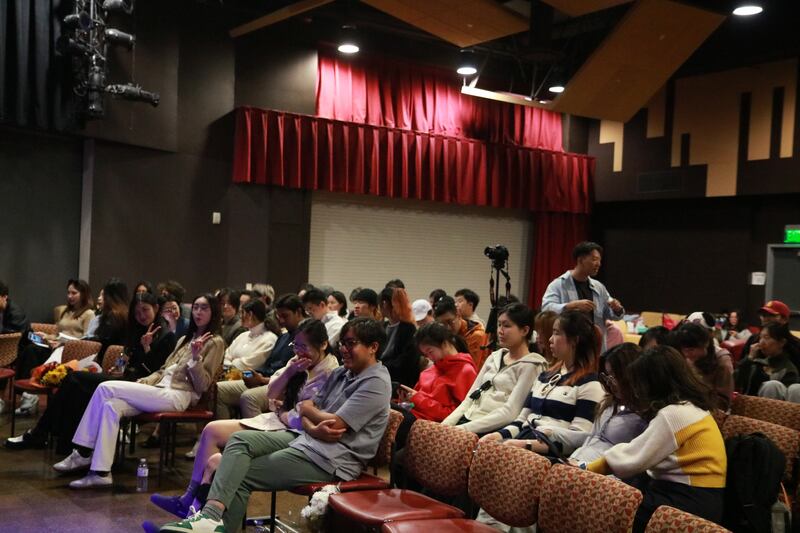 Photo of a group of students sitting in an audience in an auditorium
