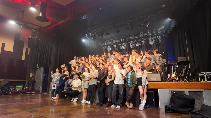 Photo of a group of people lined up in front of a stage