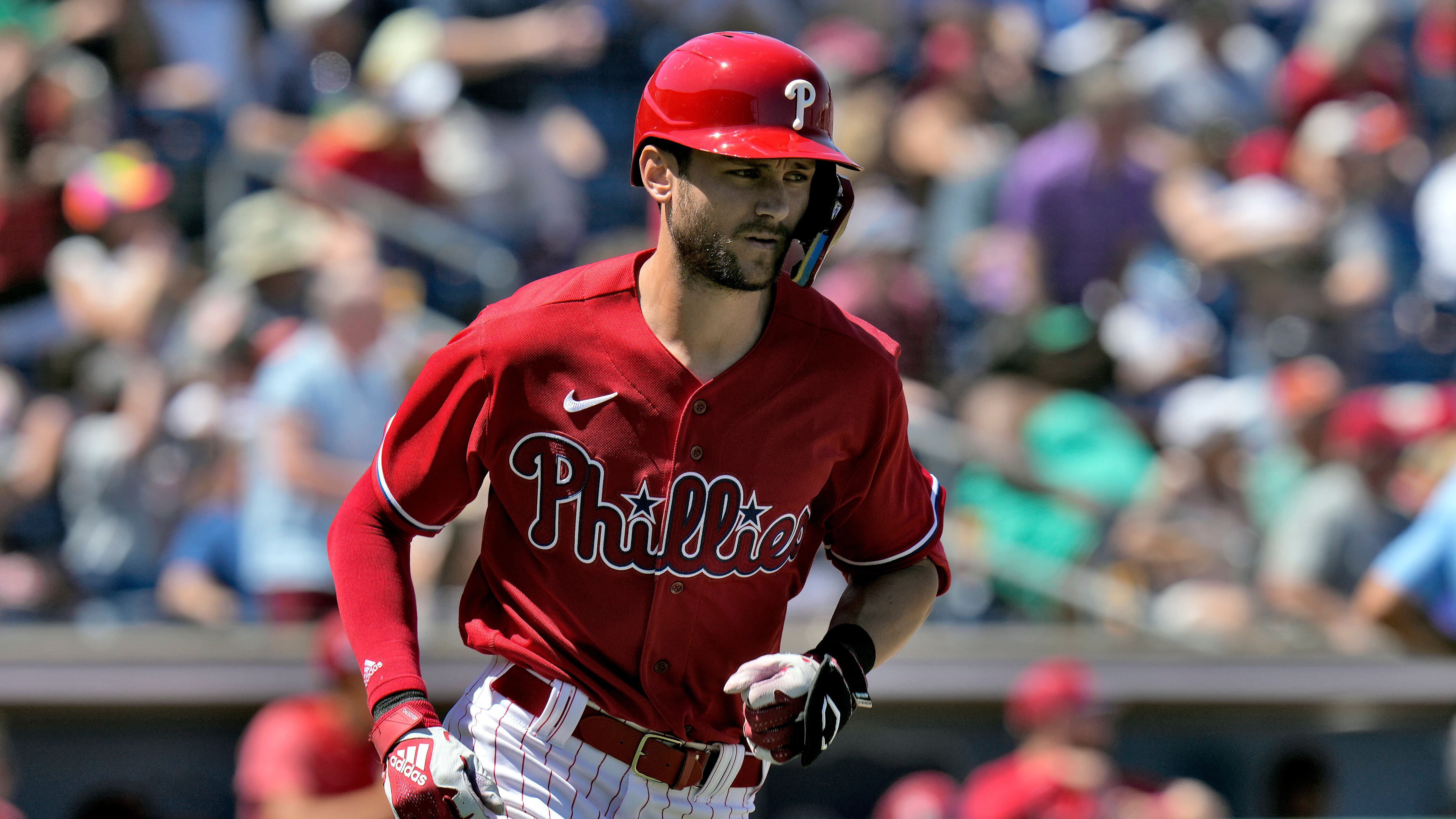 Trea Turner runs during a Phillies Spring Practice game. He is wearing white pants and a red jersey and red helmet.