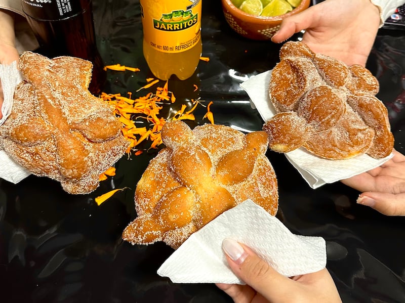 Day of the Dead bread sprinkled with icing and orange blossom petals.