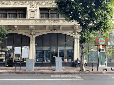 Rustic building in DTLA with arched windows and a tree in front.