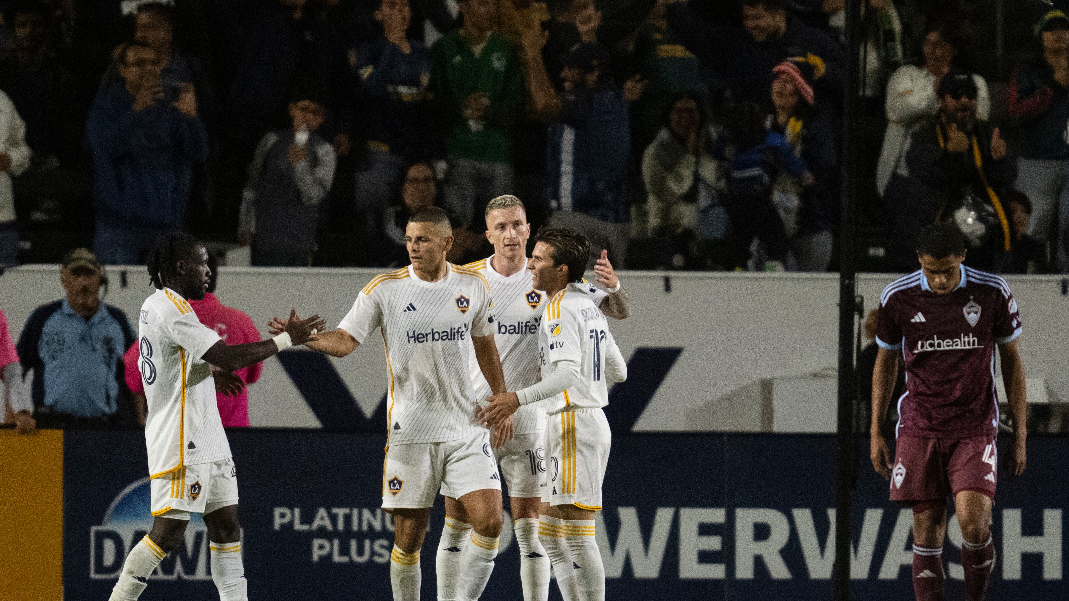 Los Angeles Galaxy forward Dejan Joveljić (9) celebrates his goal with forward Joseph Paintsil (28), midfielder Riqui Puig (10), and forward Marco Reus (18) during the second half of the first match of an MLS Cup playoffs opening round, Saturday against the Colorado Rapids, Oct. 26, 2024, in Carson, Calif.