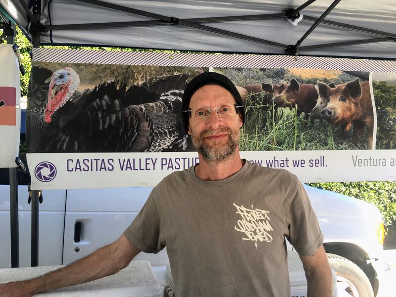 Patrick Soule stands next to his produce and meat at the Santa Monica Farmers Market.