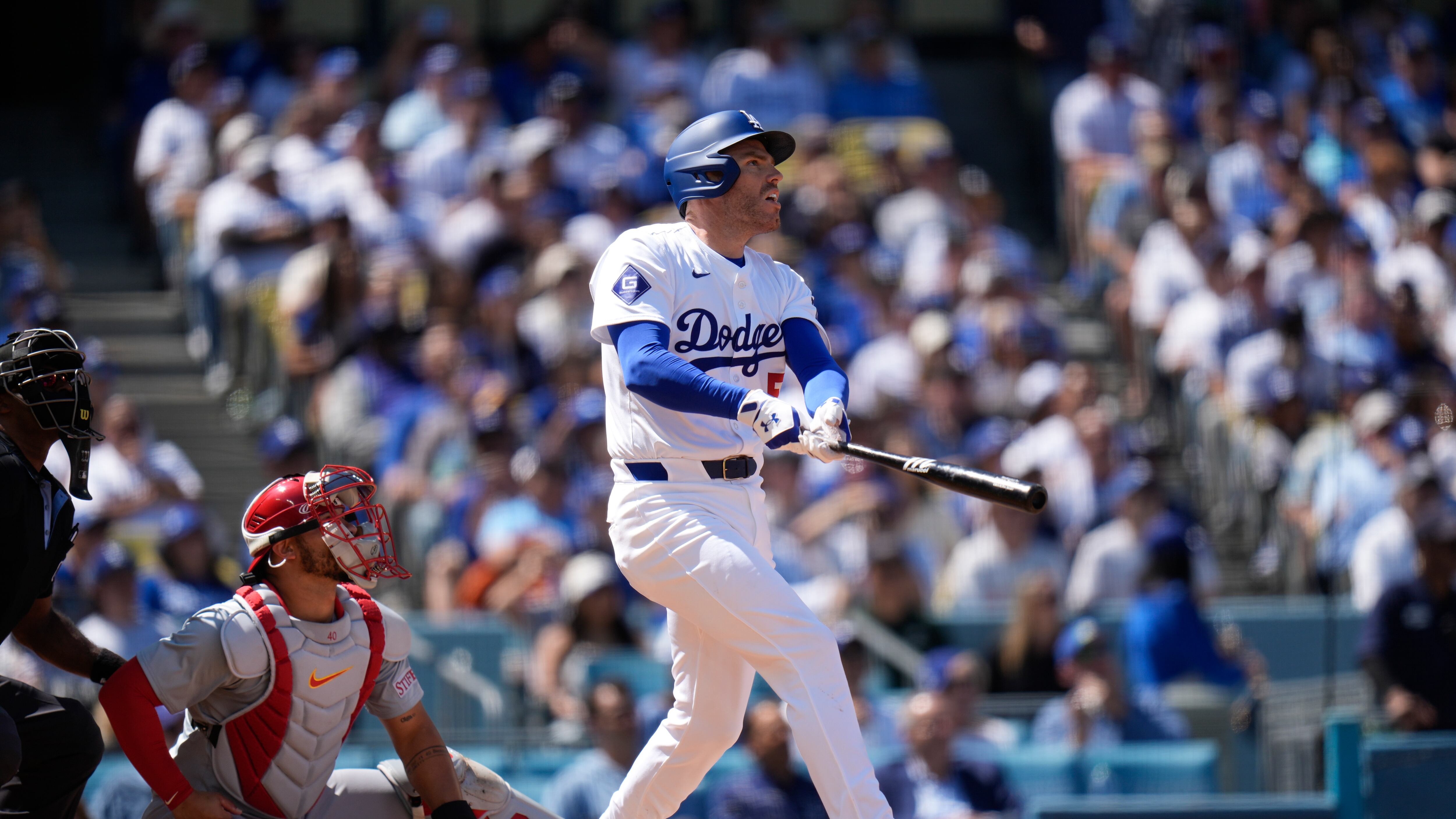 Los Angeles Dodgers' Freddie Freeman, wearing a white jersey, watches the flight of his two-run home run during the third inning of a baseball game against the St. Louis Cardinals.